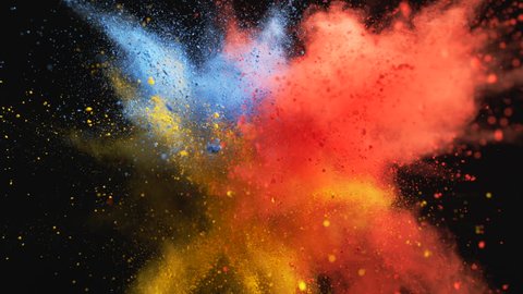 Red, yellow and blue powder/particles fly after being exploded against black background. Shot with high speed camera, phantom flex 4K. 4K 30fps. Slow Motion.