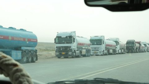 Basra, Iraq, October 2014:The Camera Gives a Passing Shot of Opposing Traffic and Fuel Tankers Parked Alongside the Road in Basra, Iraq, October 2014.