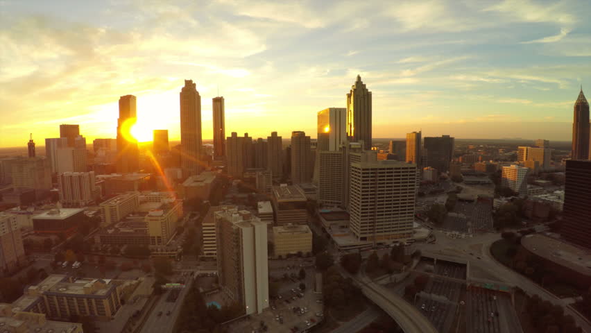 Atlanta aerial flying backwards with cityscape sunset view.