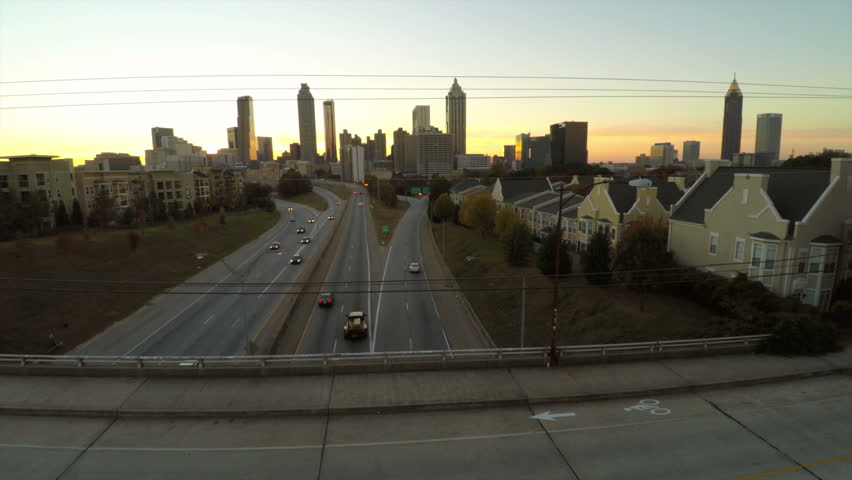 Atlanta aerial flying over Freedom Parkway with cityscape sunset view.