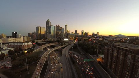 Atlanta cityscape aerial flying over freeway during dusk.