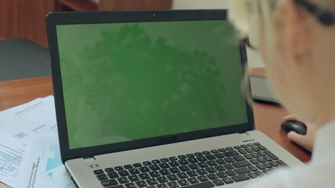 Close up of girl working at a laptop with green screen in office Arkistovideo