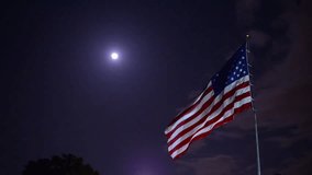American flag waves in the wind at night.