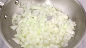 Video of cooking onions being stirred with a wood spoon.
