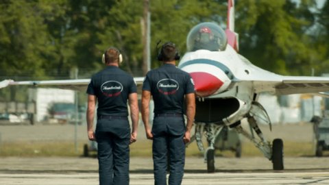 BELLEVILLE, MI, USA – AUGUST 2014:  Crew members stand at attention as US Air Force "Thunderbirds" display team F-16s taxi to runway.  Air ripples in heat haze.  Recorded in 4K, ultra high definition