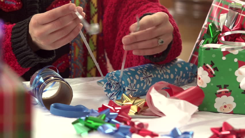 Woman wrapping Christmas gift, close up
