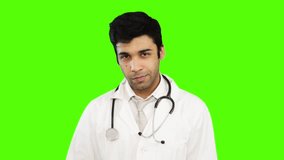 Locked-on shot of male doctor holding a medical injection against green background
