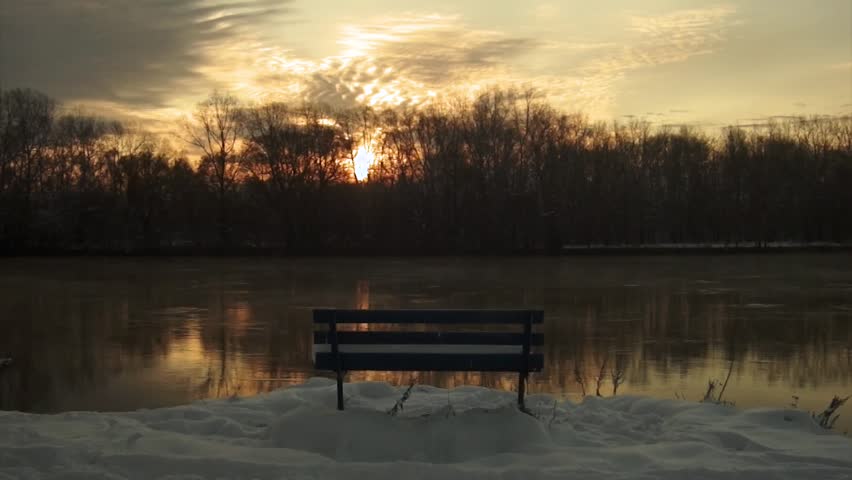 Bench by the river during sunrise