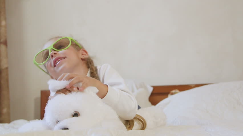 Children wearing passive 3d glasses watching TV on the bed