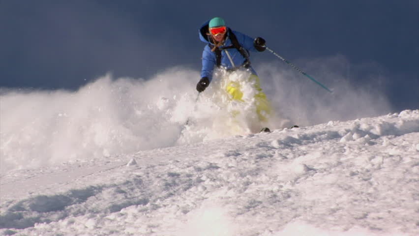 Expert woman skis deep powder snow tight shot, Alta, Utah.  Alta Ski Area is located in the Wasatch Mountains in Little Cottonwood Canyon and receives several hundred of inches of light powder snow.