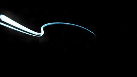 A blue light streak whips around a black background with smoke and light particles