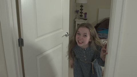 A mid-shot of a young girl running upset into her bedroom. She shouts at camera before slamming the door.