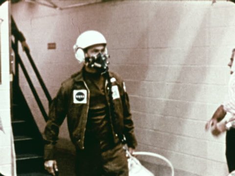 CAPE CANAVERAL, FLORIDA - CIRCA 1972: Astronauts in trainings, all wearing respirators, walk into an isolation chamber.
