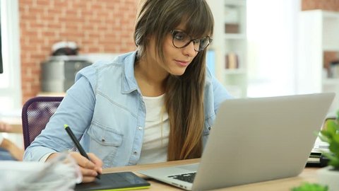 Young woman working with graphic tablet in office