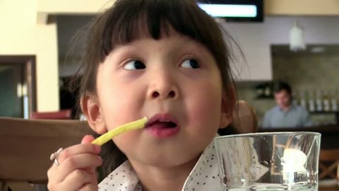 Young Asian girl eating a french fry