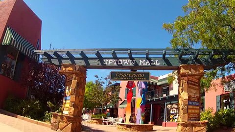 SEDONA, AZ: September 29, 2014- Rolling shot through an uptown mall with shops and people circa 2014 in Sedona. A couple of female shoppers stroll through a colorful outdoor shopping plaza.