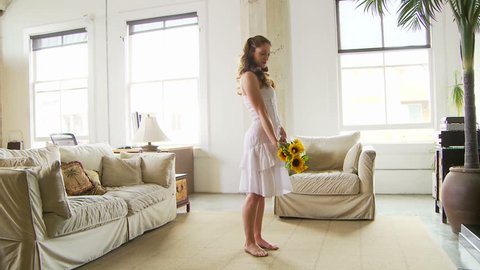 Woman dancing in living room with sunflowers