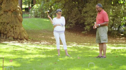Mature Black Friends Playing Croquet Outside in a Park