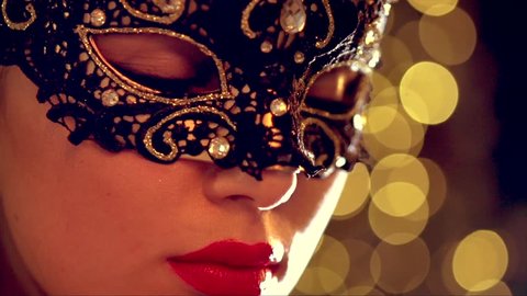 Closeup of sexy woman wearing venetian masquerade mask at party, over holiday glowing background. HD 1920x1080p, slow motion 240 fps, high speed camera shot