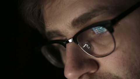 Portrait of a young man with glasses who works at night.  Close up