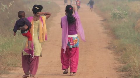 Indian women with children are on a rural road