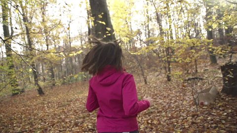 Woman jogging in forest during autumn, super slow motion, shot at 240fps
