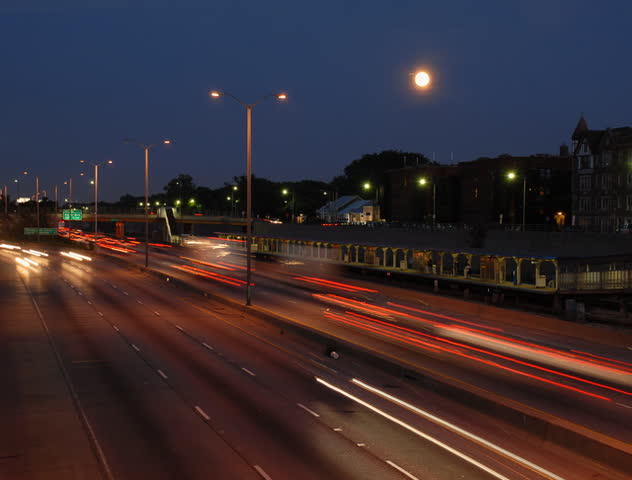Moon rises over city rush hour motion blur time lapse