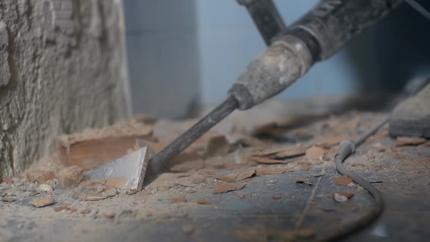 Drilling under blue ceramic tiles. Removing old ceramic tiles with special long and strong drill attached to electric drill