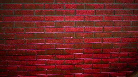 Red brick wall in restaurant under changing lighting.
