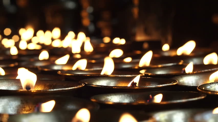 Close up of candles burning at Swayambhunath Stupa (aka Monkey Temple) in Kathmandu, Nepal.