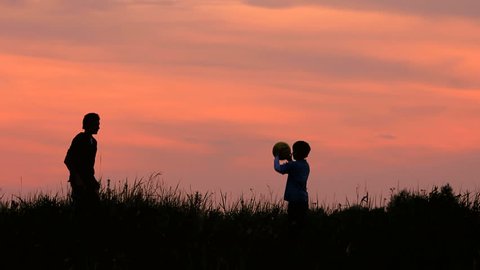Children throw a ball, sunrise