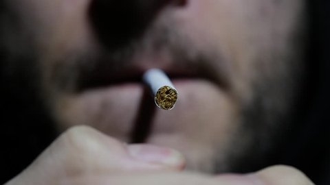 Slow motion, super close up shots of a man smoking a cigarette blowing smoke. Macro. 96fps.