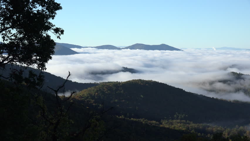 Pan across view of low cloud in valley from Blue Ridge Parkway outtook near Ashville, NC