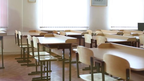 Classroom with rows of desks and chairs and windows 스톡 비디오