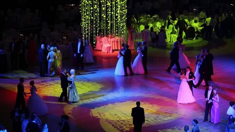 MOSCOW, RUSSIA - MAY 25, 2013: Waltzing people in colored lights at 11th Viennese Ball in Gostiny Dvor