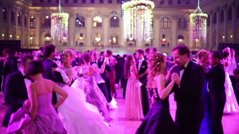 MOSCOW, RUSSIA - MAY 25, 2013: Waltzing pairs in pink light at 11th Viennese Ball in Gostiny Dvor
