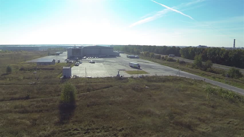  Up over Cargo  warehouse  and highway with cars . Aerial