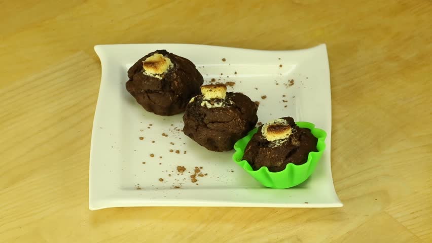 Chocolate muffins rotate on a wooden boards background
