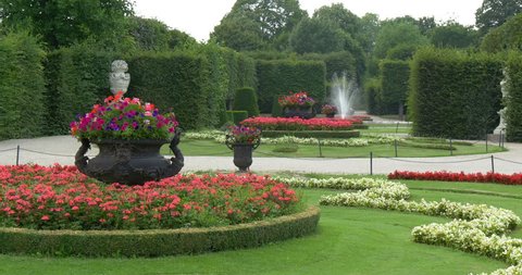 Green garden landscape design with trees, grass, flowers and water fountains, summer nature outdoor background, travel to the beautiful Schonbrunn Palace park in Vienna city, Austria, Europe