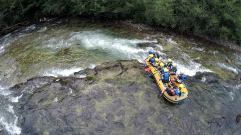 OSILNICA, SLOVENIA - AUGUST 2014: Rafting aground on river rocks in canyon. Aerial shoot of adventure rafting team aground on river rocks in canyon in Slovenia
