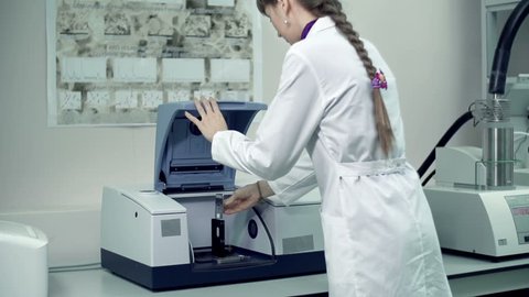 Laboratory assistant checking the result of scientific experiment with infrared spectrometer