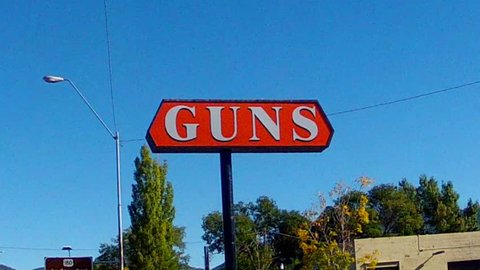 FLAGSTAFF, AZ: October 9, 2014- Low angle view looking up at a generic sign advertising guns circa 2014 in Flagstaff.  Weapons, guns, ammunition and debate of second amendment rights are a hot topic.