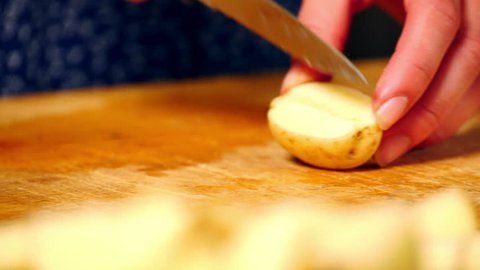 Woman preparing a healthy meal by cutting up potatoes