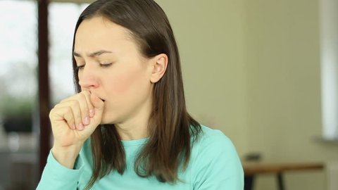 Sick young woman is coughing, close up