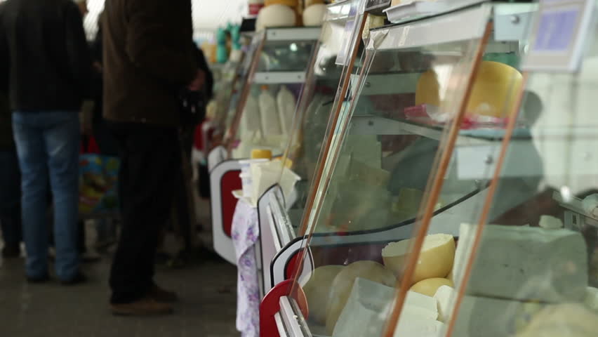 Crowded place with people at the organic healthy market, looking for meat, dairy, vegetables, honey from the local farmers.