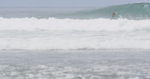 August 04, 2014 - Trestles, California. 4K slow-motion male surfer catching medium to small wave
