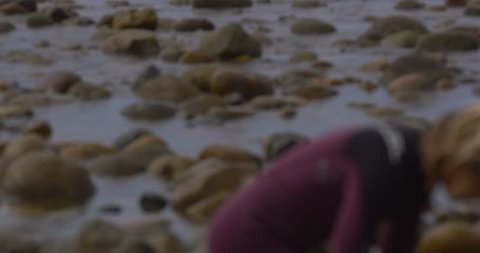 August 04, 2014 - Trestles, California 4K slow-motion boy on rocks pans to ocean behind him.