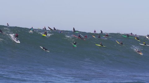 Stand up paddle boarder surfs big wave at Mavericks, CA. Jet skis in foreground. Boat angle.