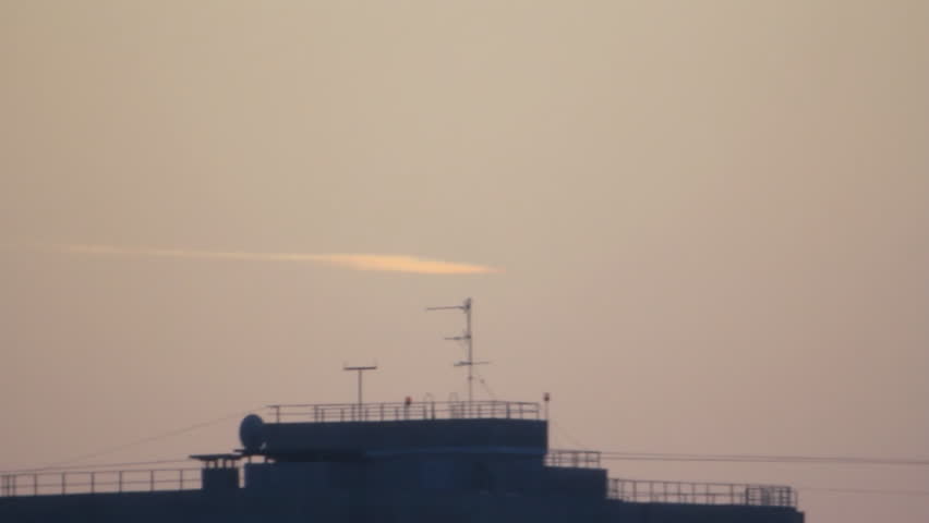 White track in sky over skyscraper roof