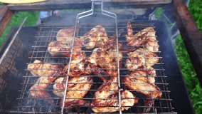 Tasty chicken wings on grill grid in sunny day close up